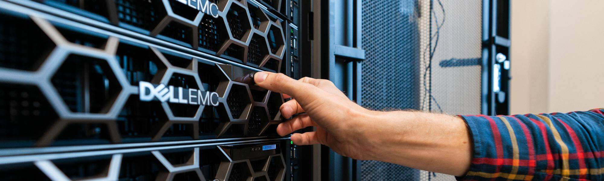 a rack of servers with a hand adjusting